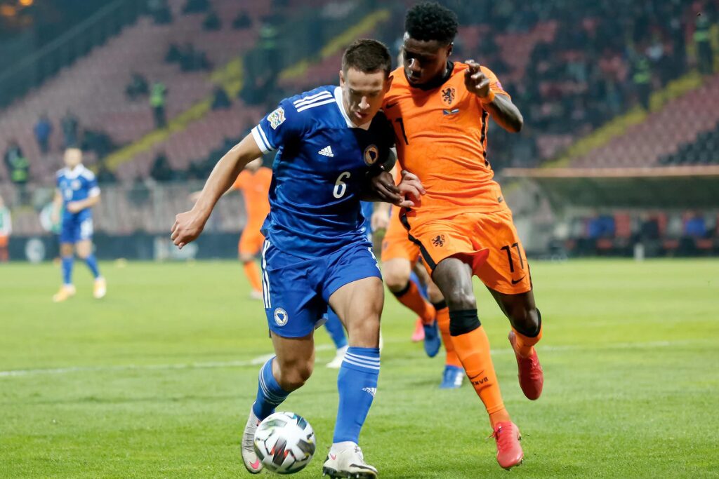 Jogadores de Bósnia e Holanda em ação